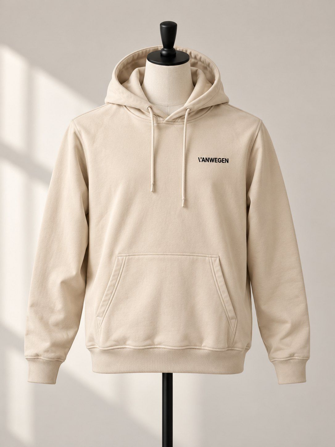 Beiger Hoodie mit gesticktem VANWEGEN-Logo auf Schneiderpuppe